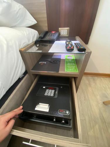 a room with a bed and a table with remote controls at Hotel Boutique Reyall in Santiago