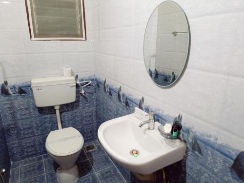 a bathroom with a toilet and a sink and a mirror at KBS Home Ramapuram in Chennai