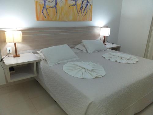 uma cama branca com duas mesas de cabeceira e dois candeeiros em Lisboa Palace Hotel em Alta Floresta