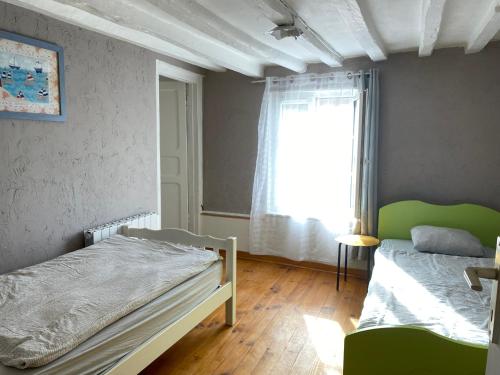 une chambre avec deux lits et une fenêtre dans l'établissement Maison de ville, à La Cressonnière