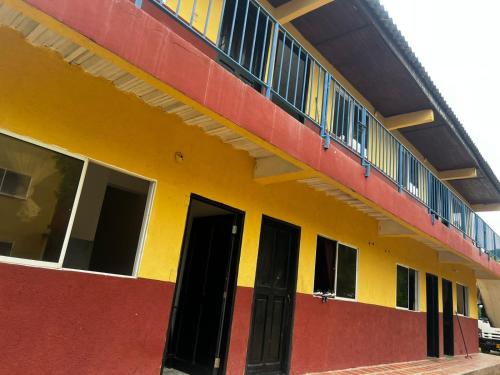 a yellow and red building with a balcony at Apartamentos Coveñas in Coveñas