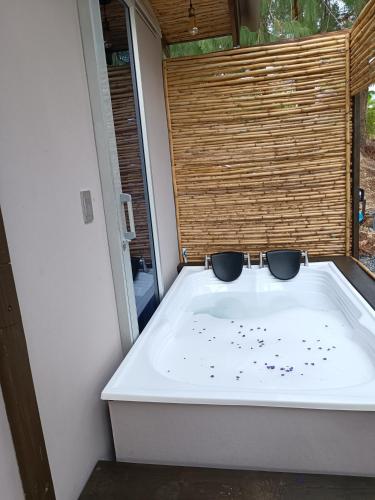 a bath tub in a room with a window at Amonitas Glamping Deluxe in Tinjacá