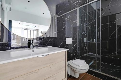 uma casa de banho com um lavatório, um WC e um espelho. em Magnificent loft Porte Versailles & Champs de Mars em Paris