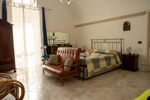 1 dormitorio con 1 cama y 1 silla en Masseria Dimora del viandante - by Click Salento en Sogliano Cavour