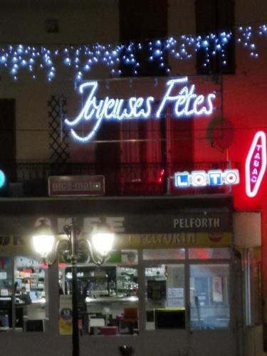 a neon sign on the front of a store at Studio chaleureux à Puget-Théniers, 27 m² avec vue montagne in Puget-Théniers