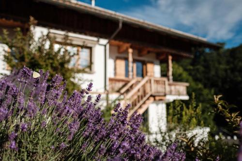 ein Haus mit lila Blumen davor in der Unterkunft Das Alpbach Tegernsee - Design Suites in Tegernsee