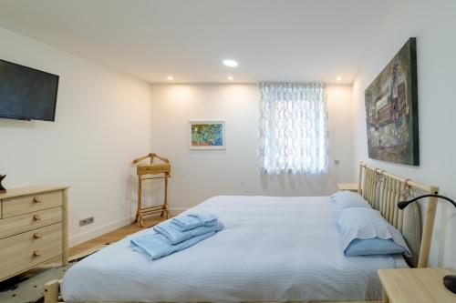 Un dormitorio con una gran cama blanca y un escritorio. en Alojamiento Singular, en Zamora