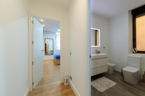 Un baño blanco con lavabo e inodoro. en Alojamiento Singular, en Zamora