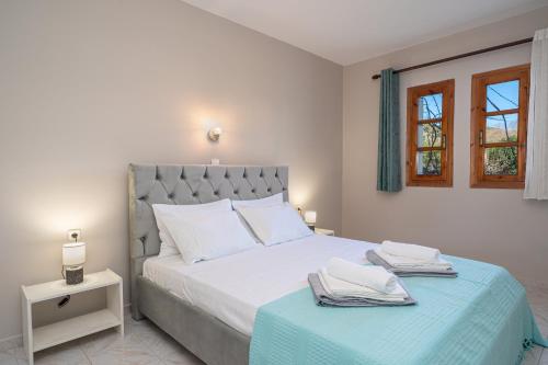 a bedroom with a large bed with a blue blanket at Southbank seafront apartments in Katelios