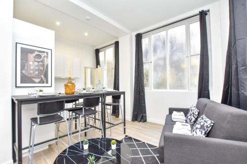 un salon avec une table et un canapé dans l'établissement Modern 3BD for 8 guests in Bastille Voltaire, à Paris