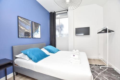 une chambre avec des murs bleus et un lit avec des oreillers bleus dans l'établissement Modern 3BD for 8 guests in Bastille Voltaire, à Paris