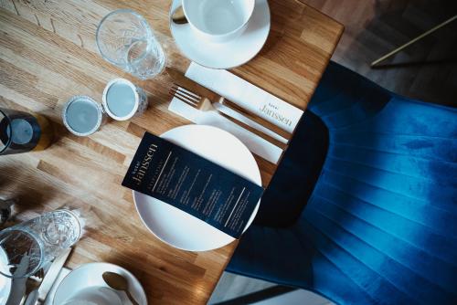 a table with a book and plates and glasses at Hotel Janssen in Valkenburg