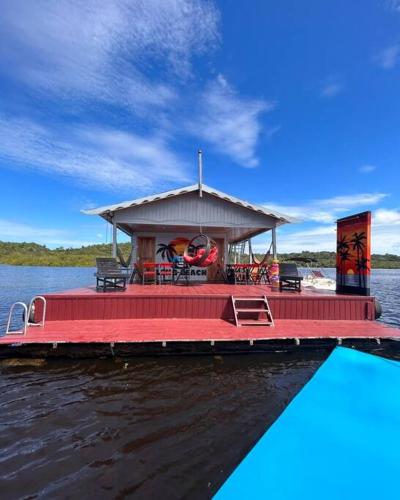 a boat with a red deck on the water at Flutuante Long Beach Manaus Am in Manaus