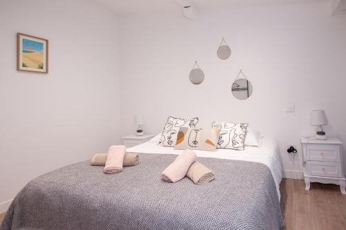 ein weißes Schlafzimmer mit einem Bett mit zwei Kissen in der Unterkunft Apparts Gambetta in Libourne