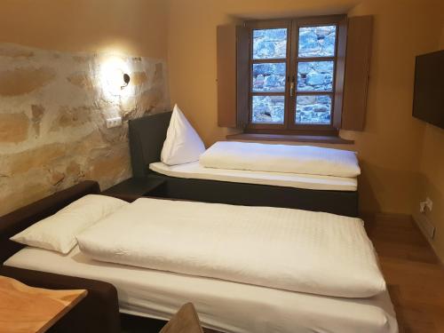 two beds in a room with a window at Boardinghouse Stadtmauer in Schwandorf in Bayern