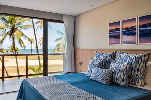a bedroom with a bed with a view of the beach at Luxo a 50 m da praia, acesso ao Iberostar Resort in Praia do Forte