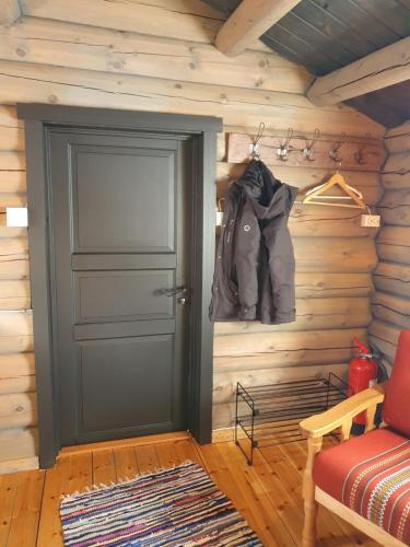 Bjørgebu Camping AS في Mysusæter: باب في كابينة خشب مع سترة على الحائط