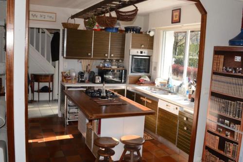 - une cuisine avec un comptoir et des tabourets dans l'établissement Ty Clafout Vannetaise parking wifi linge non inclus, à Saint-Nolff