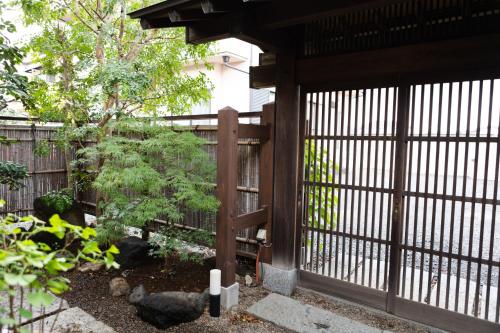 a fence with a gate with chickens in a garden at 結家 -MUSUBIYA- in Kawagoe