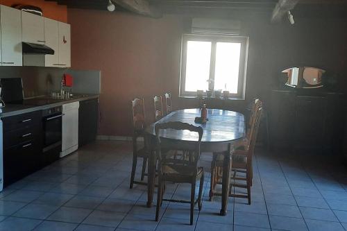 eine Küche mit einem Tisch und Stühlen sowie einem Fenster in der Unterkunft Villa de 3 chambres avec terrasse et wifi a Saint Georges de Baroille in Saint-Georges-de-Baroille