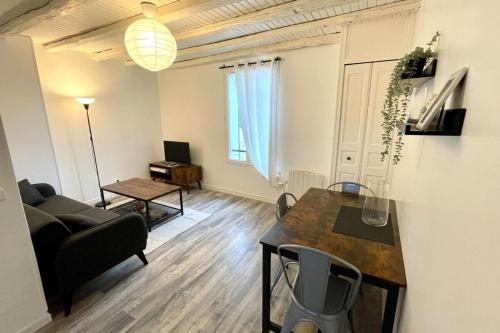 een woonkamer met een bank en een tafel bij Suites Rive Gauche - Proche Fontainebleau - Chez Christophe in Montereau-faut-Yonne
