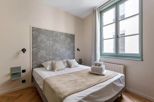 a bedroom with a bed and a large window at HAMAC Suites / Suite St Antoine / 2 CH / Unique in Lyon