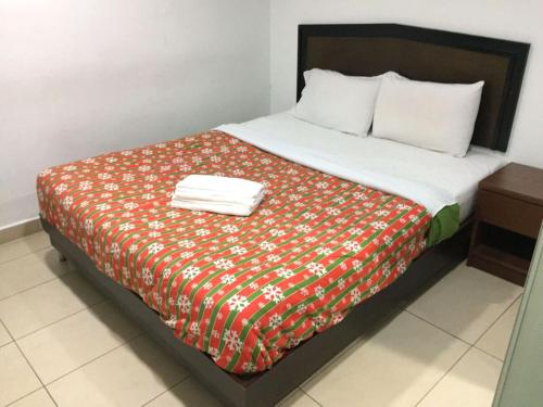 een bed met een rode en witte deken erop bij HP Rooms All Star Hotel in Melaka