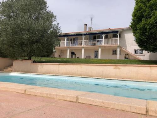 a house with a swimming pool in front of it at Maison à 6 km de Eymet piscine chauffée. in Roumagne