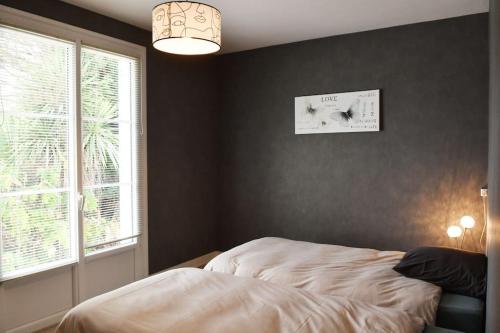 een slaapkamer met een bed naast een raam bij Maison à 6 km de Eymet piscine chauffée. in Roumagne