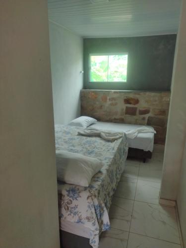 um pequeno quarto com 2 camas e uma janela em Aurora suites chapada Diamantina em Lençóis