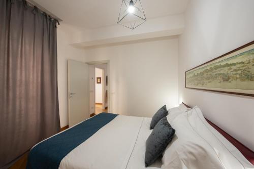 熱那亞的住宿－U Genova，卧室配有白色的床和墙上的绘画作品