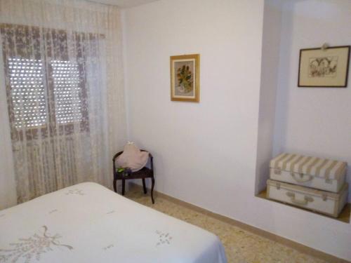 a bedroom with a bed and a chair and a window at 2 bedrooms appartement at Lucoli in Casavecchia