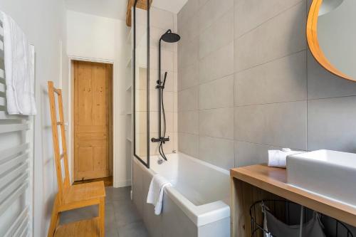 a bathroom with a tub and a sink and a mirror at Flat Fourvière view / Near Place des Terreaux in Lyon