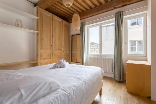 a bedroom with a white bed and a large window at Flat Fourvière view / Near Place des Terreaux in Lyon