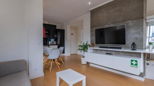 a living room with a flat screen tv on a wall at Sunny Horizon Retreat by LovelyStay in Paço de Arcos