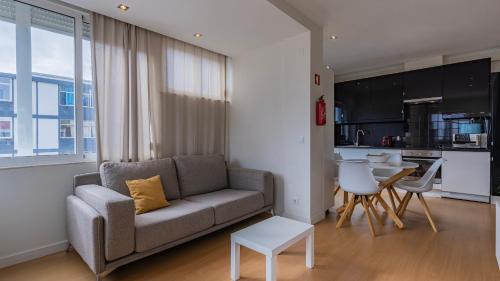 a living room with a couch and a table at Sunny Horizon Retreat by LovelyStay in Paço de Arcos