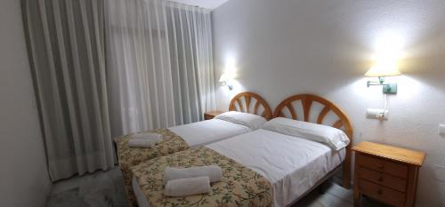 1 dormitorio con 1 cama con 2 almohadas en Paraiso Esperanto - Fincas Arena, en Benidorm