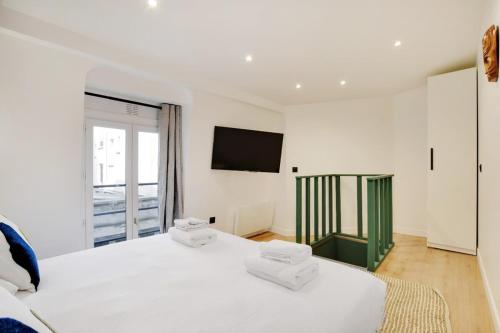 une chambre avec un lit blanc et une télévision à écran plat dans l'établissement Place d'Italie Modern & Renovated 3BD for 10guests, à Paris