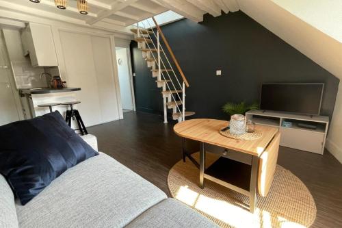 un salon avec un canapé et une table dans l'établissement Duplex - Chez Florian, à Fontainebleau