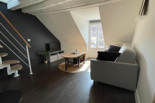 un salon avec un canapé et une table dans l'établissement Duplex - Chez Florian, à Fontainebleau