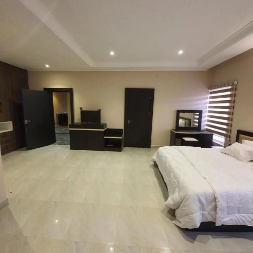 - une grande chambre avec un lit et un bureau dans l'établissement Safari Court, à Abuja