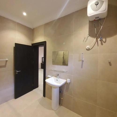 La salle de bains est pourvue d'un lavabo et d'un sèche-cheveux sur le mur. dans l'établissement Safari Court, à Abuja