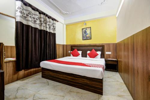una camera da letto con un grande letto con cuscini rossi di Woods Imperial Kufri a Shimla