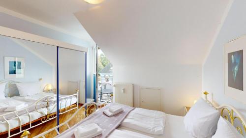1 Schlafzimmer mit 2 Betten und einem großen Fenster in der Unterkunft NeuKlosterhof App. 23 in Pelzerhaken