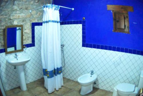ein blaues Badezimmer mit WC und Waschbecken in der Unterkunft 4 bedrooms house with shared pool and wifi at Granada in Montefrío