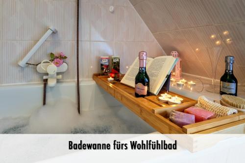 - une baignoire avec 2 bouteilles de vin sur une étagère dans l'établissement Schindelhäusle Schillerstraße, à Alpirsbach