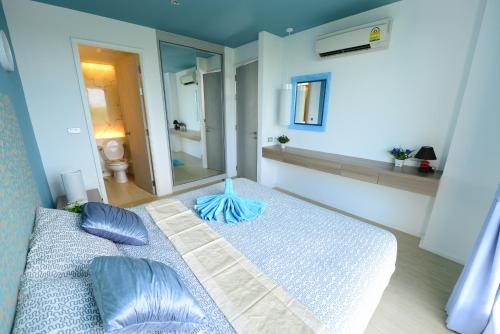 a bedroom with a large bed with blue pillows at Atlantis Condo Resort Pattaya in Jomtien Beach