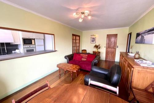 sala de estar con sofá rojo y mesa en Suites Rive Gauche - Chilly Mazarin - Chez Helene en Chilly-Mazarin
