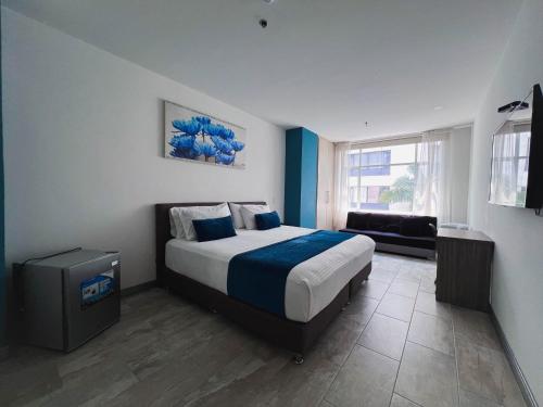 Hotel Rosales Gold في بيريرا: غرفة نوم مع سرير مزدوج كبير في غرفة