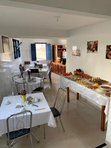 un restaurant avec des tables et des assiettes de nourriture dans l'établissement Pousada Brilho da Chapada New, à Lençóis